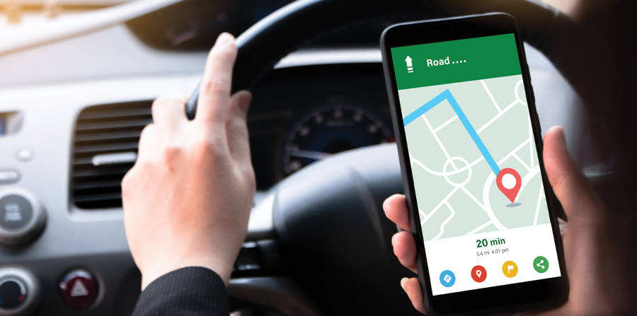 woman sitting in front of the driver in the car i m using a smartphone to look at a map showing the route of travel and use the application to get to the destination black car steering wheel handle